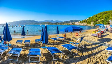 Typical vacation beach with beachchairs and sunshades at sunset