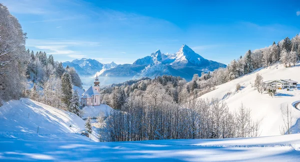 Vinterlandskab i de bayerske alper med kirke, Bayern, Tyskland - Stock-foto