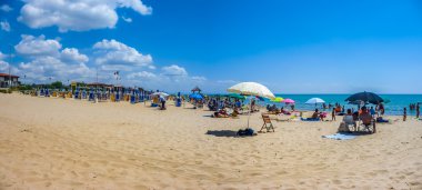 Vacation beach with beachchairs and sunshades on a sunny day