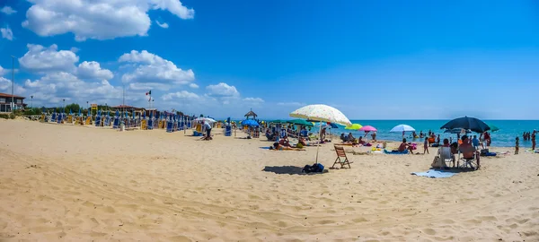 Пляж с пляжными креслами и зонтиками в солнечный день — стоковое фото