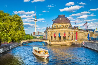 Berlin Museumsinsel with TV tower and excursion boat on Spree river at sunset, Germany
