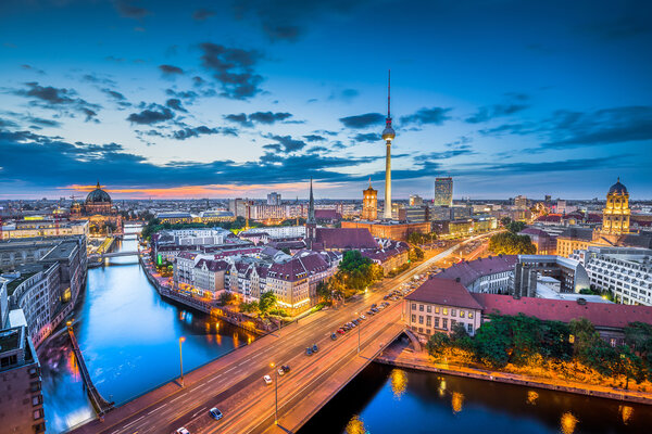 Aerial view of Berlin skyline with dramatic clouds in twilight during blue hour at dusk, Germany.