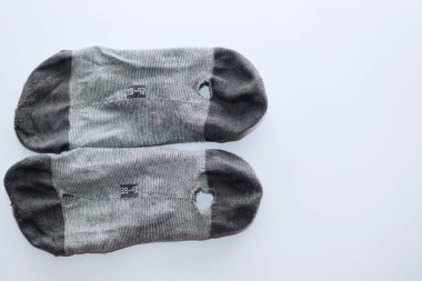 Beyaz arka planda gri bir çift çorap. Giysileri eskimiş.