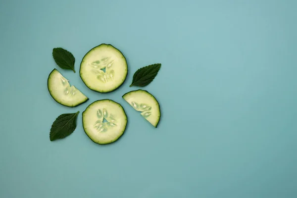 Círculos Semicírculos Pepino Com Folhas Casa Moeda Verdes Contexto Azul — Fotografia de Stock