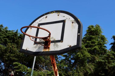 Ağ olmadan paslı basketbol çemberi. Eski bir metal basketbol tahtası..