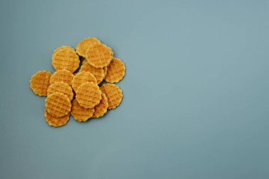 Mavi arka planda küçük yuvarlak waffle seti. Yukarıdan görüntüle 