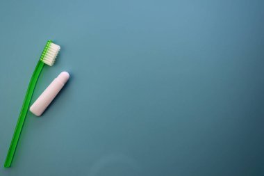 Diş fırçası ve mavi arka planda küçük bir tüp diş macunu. Dişlerini fırçalamak için seyahat çantası.. 