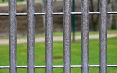 Bulanık yeşil arka planda dikey metal eskrim direkleri. 