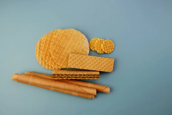 Mavi arka planda üç çeşit waffle. Yuvarlak waffle 'lar, dolu waffle' lar ve uzun gofretler.. 