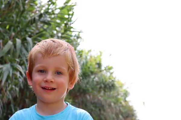 배경에 금발의 소년의 살짜리 아이가 카메라를 벌리고 미소짓습니다 — 스톡 사진