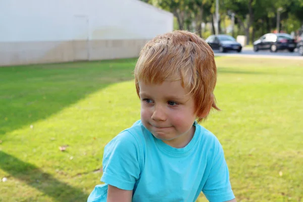 Blonde Jongen Kijkt Naar Zijkant Terwijl Hij Zijn Lippen Spint — Stockfoto