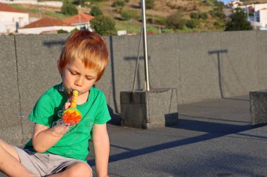 Sarışın çocuk sabun köpüğü yapıyor. Dört yaşında bir çocuk sabun köpüğüyle oynuyor.. 