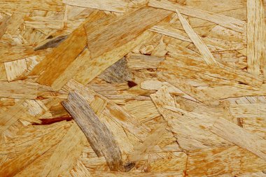 Yüksek çözünürlüklü iplik (OSB) doku arka planı. Rastgele ahşap parçaları ve pullu desenli doğal ahşap yüzey. İnşaat malzemesi arkaplanı, rustik kontrplak detayı.