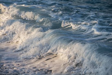 Deniz kenarında beyaz köpüklü mavi deniz dalgası