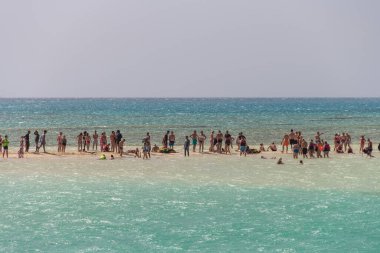 Mısır, 4.10.2025 - Sharm el-Sheikh 'deki Ras Mohammed Doğa Rezervi' ndeki Beyaz Ada, turkuaz sularla çevrili, güneşli bir günde dinlenen turistler. Açık denizin ortasındaki dar bir kumsalda bir grup insan. Mısırlı Maldivler.