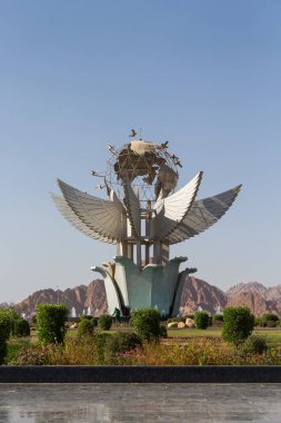 Mısır, 3.10.2025 - Sharm el-Şeyh 'teki Barış Anıtı. Bir küre ve kanatları gösteren modern bir heykel. Bir dağ zeminine ve mavi gökyüzüne karşı..
