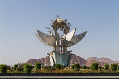 Mısır, 3.10.2025 - Sharm el-Şeyh 'teki Barış Anıtı. Bir küre ve kanatları gösteren modern bir heykel. Bir dağ zeminine ve mavi gökyüzüne karşı..