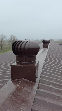 Turbo ventilator deflectors on the metal roof of an industrial building. Natural ventilation system on a roof in a rural area.