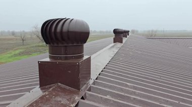 Turbo ventilator deflectors on the metal roof of an industrial building. Natural ventilation system on a roof in a rural area.