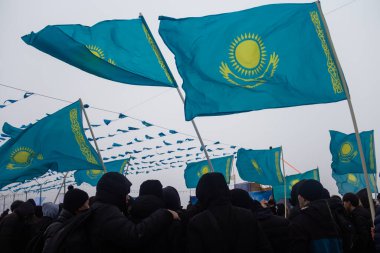Astana, Kazakistan (Kazakistan), 23 Şubat 2026 - Bir kalabalık açık hava etkinliğinde Kazakistan bayraklarını tutuyor. Referandumu destekleyen vatansever bir miting. Ulusal bayrak taşıyan Kazakistan gençliği.