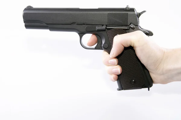 Mano sosteniendo un arma sobre un fondo blanco —  Fotos de Stock