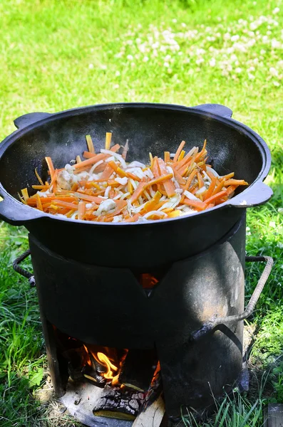 Verduras al vapor en un caldero de hierro fundido en el fuego Imágenes De Stock Sin Royalties Gratis