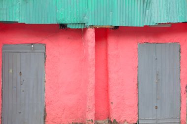 Pembe duvar-gri kapıları yeşil teneke çatı. Kombolcha-Etiyopya. 0503