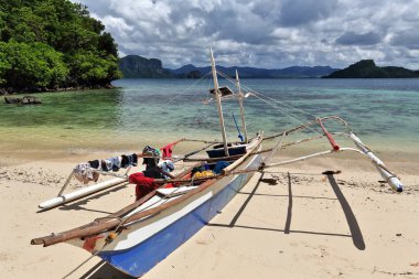 Cudugnon Point Mağara Sahili 'nden, Bacuit Körfezi' nden Palawan anakarasına ve Lagen-Pinasil-Dibuluan adalarına giden eski Filipinli bangka tur teknesinin E-ward manzarası. El Nido-Filipinler.