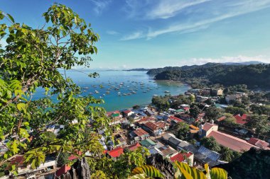 El Nido kasabası veya Poblacion 'un ortasındaki Taraw uçurumundaki gözlem güvertesinden kuzeye doğru ve arka plandaki kalabalık liman ve bay-Cadlao adasına doğru. Palawan-Filipinler.