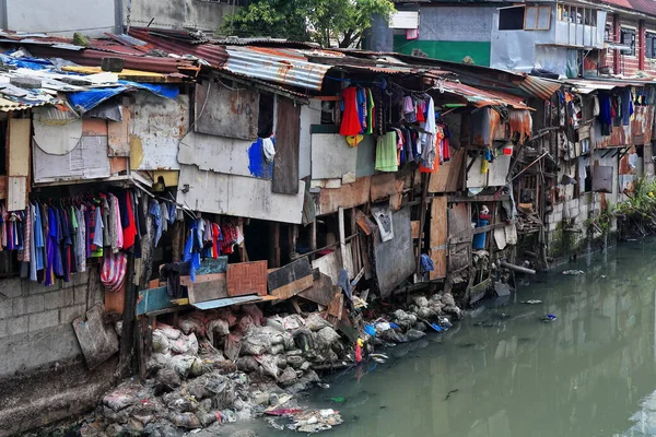 N-wards view from Soler Street bridge to the shack crowded banks of the Estero de San Lazaro channel of the Pasig river-Broadview Towers on background. Binondo Chinatown District-Manila-Philippines