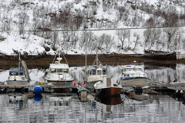 Fishing boats moored-floating pontoons-port in Sildpolltjonna inlet-S.shore Sildpollnes peninsula-abandoned shipwreck wooden boat. Konesheia mount background. Austnesfjorden-Austvagoya-Lofoten-Norway.