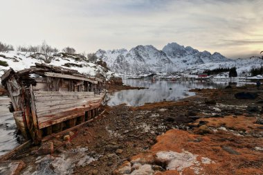 Gemi enkazı batmış ahşap tekne kıyıya vurmuş Sildpollnes Yarımadası-Austnesfjorden körfezi. Rulten-Langstrandtindan-Stortinden Dağı. Vagan kommune-Austvagoya-Lofoten-Nordland fylke-Norveç.