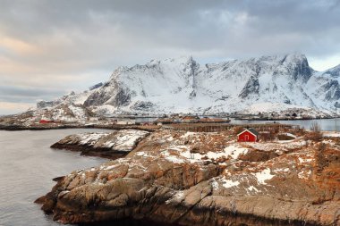 Reinevagen Körfezi-Reinefjorden çevresindeki Toppoya-Sakrisoya-Andoya adalarına doğru ters görüş. Reinebringen-Helvete-Austerdalsfellet-Veinestinden-Navaren mts 'ın ayağı. Moskenesoya-Lofoten-Norveç