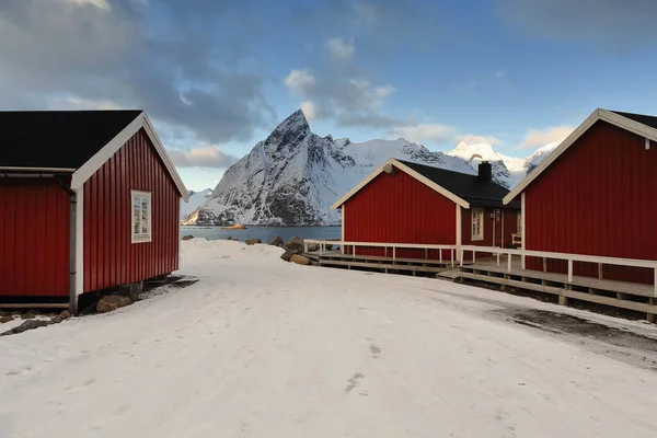 红色木制汽笛 传统的季节性渔舍 现在是供游客使用的 一端建在水柱上 奥兹滕山对面的港口入口 Hamnoy Reine Moskenes Lofoten Nordland — 图库照片