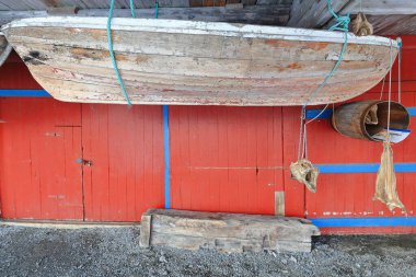 Eski balıkçı teknesi morina gövdesi ve bir zamanlar geleneksel olan kırmızı robu-önlü balıkçı kulübesiyle birlikte müzenin kullanım dışı sezonu için takılıyor. A I Lofoten-Moskenesoya-Nordland-Norveç.
