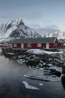 Günbatımında Reinefjorden ve Skjeret-adacığı 'nın Reinevagen-körfezi üzerinden kuzeydeki fiyordu kapatan Rostadtinden-Olstinden-Lilandstinden-Festhaeltinden. Reine-Lofoten-Nordland-Norveç.
