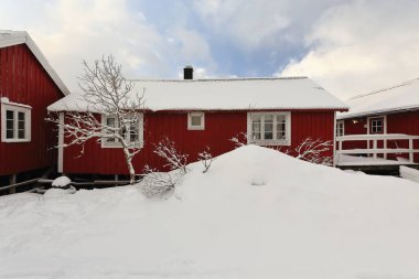 Reine kasabası yakınlarındaki Hamnoy köyünde bir zamanlar geleneksel balıkçı kulübelerinin üzerine şiddetli kar yağışı vardı. Moskenesoya-Lofoten-Nordland fylke-Norveç.
