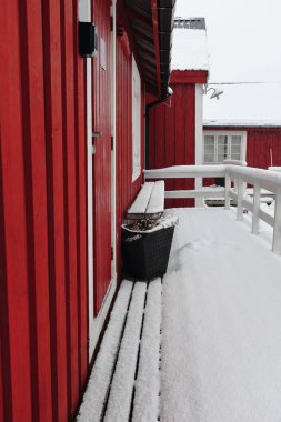 Şiddetli kar yağışı altında kırmızı ahşap kazan. Geleneksel balıkçı kulübeleri. Turist kullanımı için. Çitleri ve tezgahı dışarıda. Hamnoy-Reine-Reinefjorden-Moskenes-Lofoten-Nordland-Norveç