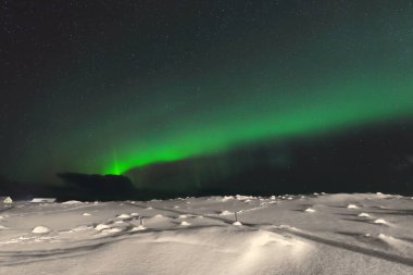 Yeşil ışıklar-aurora borealis, soğuk ve sessiz bir gecede N.N. 'den Sandelva nehir ovasından ve Sandbotnen Körfezi-N.Moskenesoya adasındaki Yttresand köyündeki plajdan aydınlanır. Lofoten-Nordland Fylke-Norveç.
