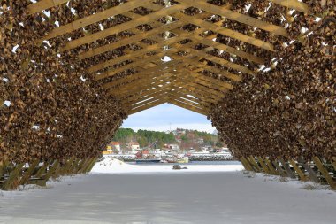Ahşap A-çerçeve rafları ya da balık olmak için hava kurutma asarken birbirine bağlanmış morina balıklarından yapılmış hjelller. Laukvik balıkçı köyü ve tekneleri Austvagoya-Lofoten-Nordland-Norveç.