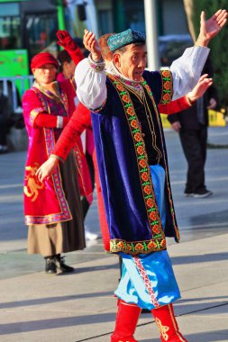 Zhangye, Çin-20 Ekim 2017: Uygurca giyinmiş yaşlı dansçılar şehrin Merkez Meydanı 'ndaki etnik müziğin sesine geleneksel koreografiler sergiliyorlar.