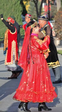 Zhangye, Çin-20 Ekim 2017: Uygurca giyinmiş yaşlı dansçılar şehrin Merkez Meydanı 'ndaki etnik müziğin sesine geleneksel koreografiler sergiliyorlar.