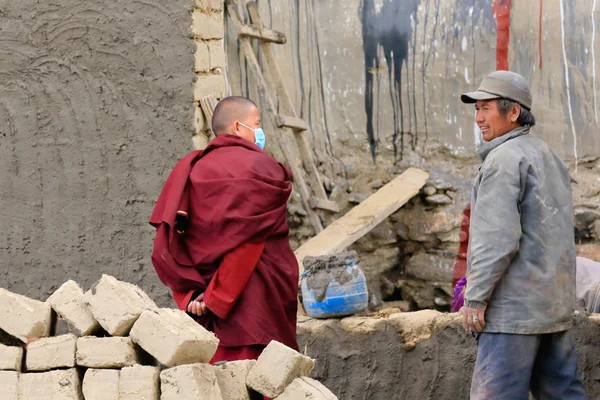 Lokal man och munk vid samhällstjänst. Sakya kloster-Tibet. 1898 — Stockfoto