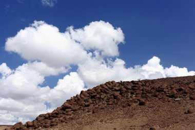 Cumulus clouds over volcanic stones-Awash river valley. Afar region-Ethiopia. 0124 clipart