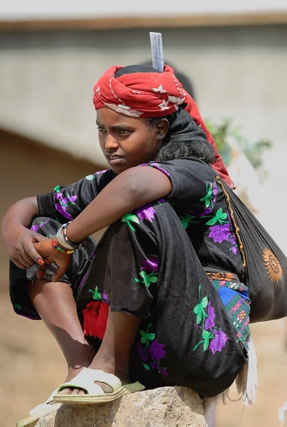 Young woman sitting on a rock. Sunday market-Senbete-Ethiopia. 0064 — Zdjęcie stockowe