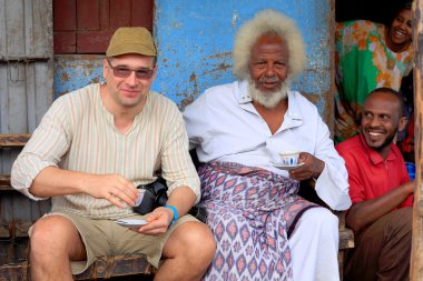 Local VIP and tourist share a coffe. Degan town-Ethiopia. 0106 clipart