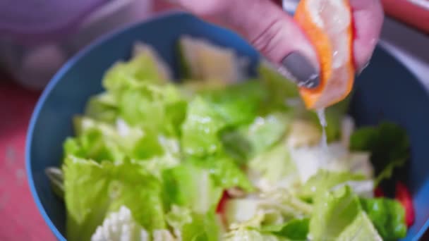 Mujer exprime jugo de limón en una ensalada — Vídeos de Stock