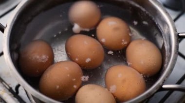 Ham sarı renkli tavuk yumurtası, kaynar suyla metal bir tavada pişirilmiş. İnsan yok. Sağlıklı beslenme. Doğal protein kahvaltısı.