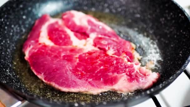 Vers vlees van rundvlees op ontstoken pan met zout en peper en specerijen, van dichtbij bekeken. Koken rundvlees biefstuk op koekenpan, heerlijke steaks worden gebakken op een grill pan — Stockvideo