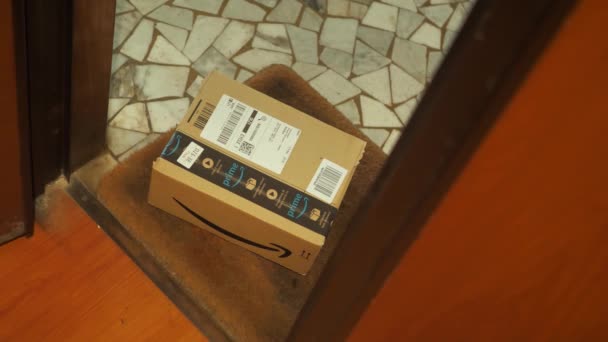 Rome Italy. October-19. 2020. A man picks up a package from Amazon from behind his front door — Stock Video